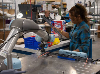 Collaborative robot working alongside a human in a manufacturing facility